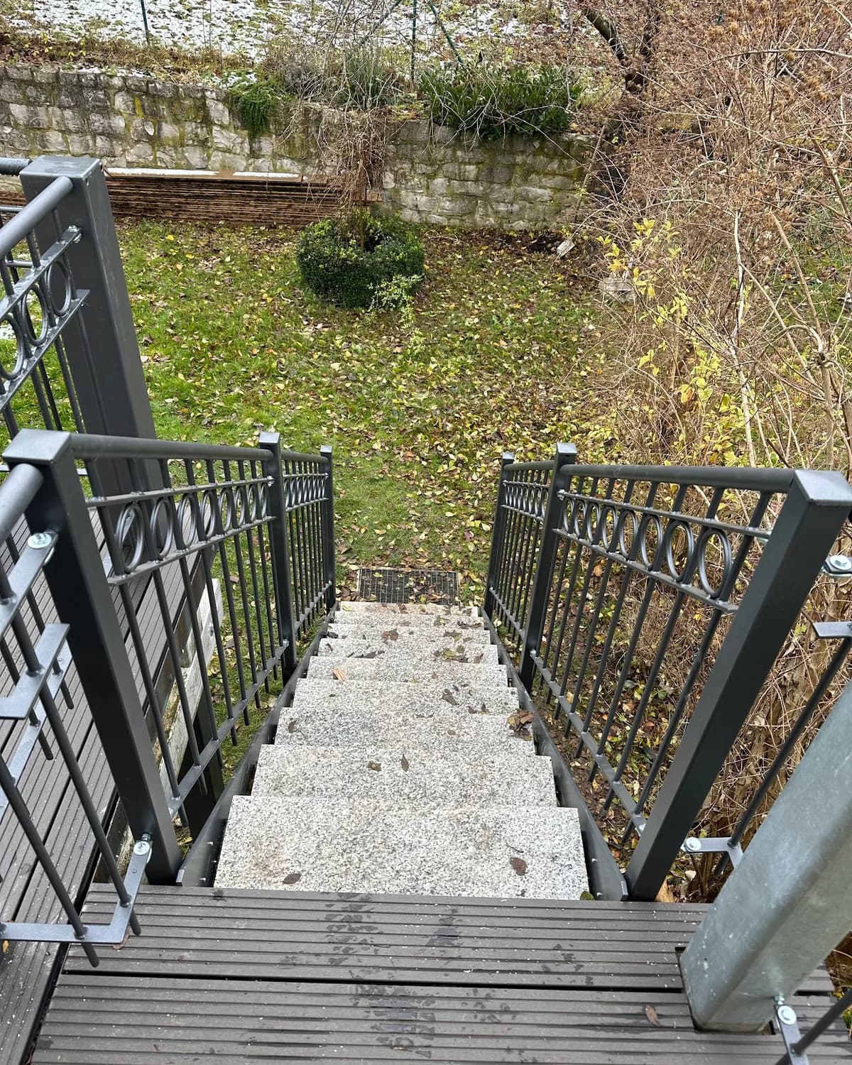 Anthrazitfarbenes Stabgeländer an einer Außentreppe aus Naturstein